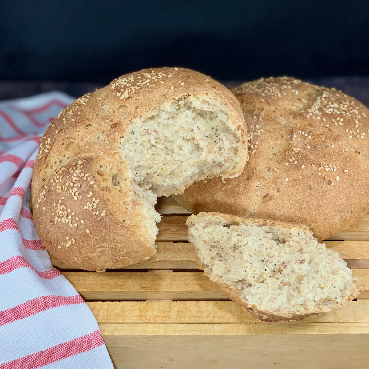 Closeup of Multigrain Sourdough Bread on cutting board with torn loaf and piece square