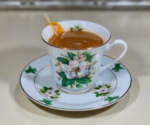 rum punch cocktail in china cup closeup wide