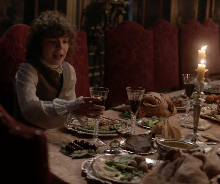 Fergus enjoys the remains of dinner in Outlander Season 2