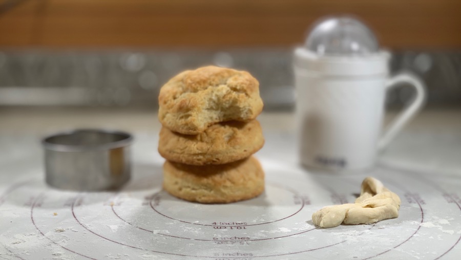 stack of finished sourdough biscuits with cutter & flour shaker