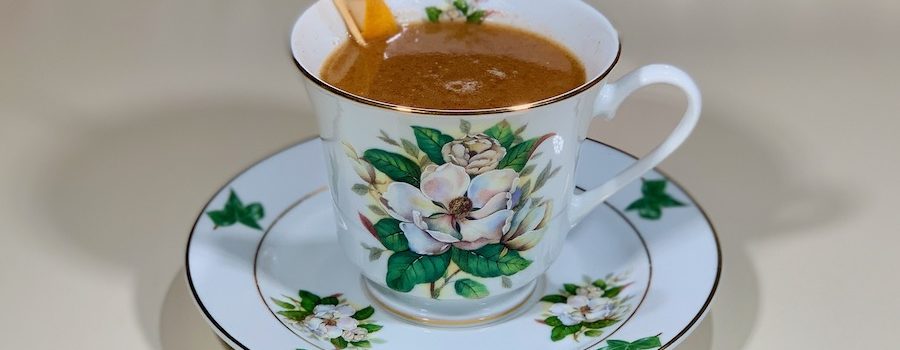 rum punch cocktail in china cup closeup wide