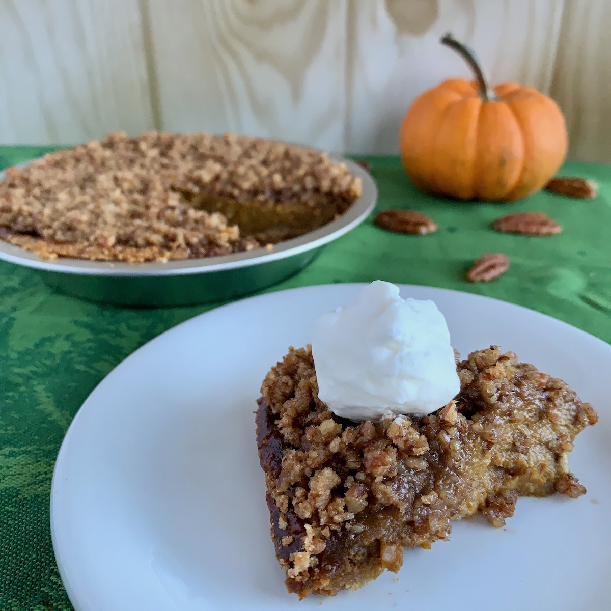 Praline Pumpkin Pie slice plated closeup & pie & pumpkins behind