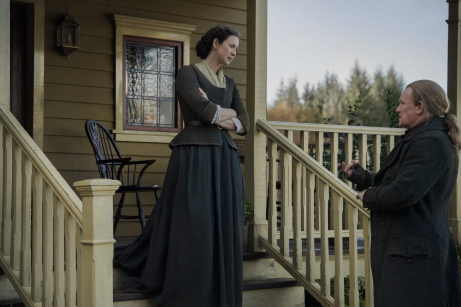 Claire and Tom Christie conversing on the front steps of the Big House.