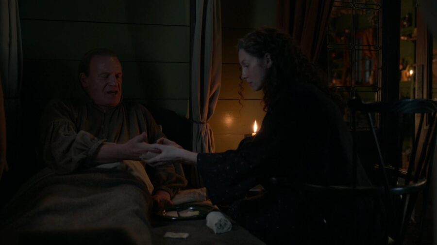 Claire sits by Tom in the surgery and checks his hand. 