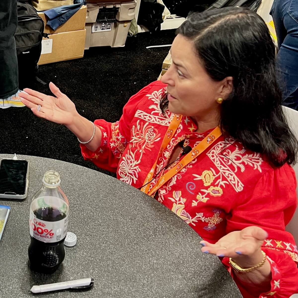 Diana Gabaldon gesturing as she sits for an interview with a Diet Coke on the table.