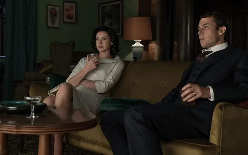 Full spoilers for Outlander Season 3 Episode 3, “All Debts Paid.” This podcast page is spoiler-free for future book events beyond this episode. In this episode of Outlander Cast, Mary recaps and reacts to Outlander Season 3 Episode 3, “All Debts Paid,” live from Martha’s Vineyard with members of the Outlander Cast staff. Blake joins from afar, emotionally unwell about saying goodbye to Frank Randall, and returns at the end to promise many more Frank feelings in the listener feedback episode. Quick answer: “All Debts Paid” is the episode where Frank Randall’s goodbye hurts more than it probably should. Frank dies after years of trying, failing, loving Brianna, resenting Claire, and living inside a marriage that never fully survived Jamie. At the same time, Jamie meets Lord John Grey at Ardsmuir, Murtagh returns, and Season 3 opens a new emotional lane for Jamie after years of grief, prison, and survival. That is what makes the episode so specific. It is not simply “the episode where Frank dies” or “the episode where Lord John shows up.” It is the episode where Outlander asks us to feel the weight of a man many viewers were ready to lose — and then complicates that feeling by reminding us that Frank was Claire’s first love, Brianna’s father in every meaningful daily sense, and one half of a marriage that was never clean enough to hate. Start With Our Outlander Season 3 Guide This episode continues the Voyager arc, moves Jamie deeper into Ardsmuir, and closes a major chapter in Claire’s twentieth-century life. For every Season 3 podcast, recap, listener feedback episode, article, and explainer, start with our Outlander Season 3 Episode Guide. Listen And Watch: Outlander Season 3 Episode 3 Recap & Reaction Watch our full Outlander Season 3 Episode 3 recap and reaction for “All Debts Paid” below. This episode of Outlander Cast covers Frank’s death, Tobias Menzies’ farewell, Claire’s complicated goodbye, Lord John Grey’s introduction, Jamie’s role as leader at Ardsmuir, Murtagh’s survival, David Berry’s casting, the show’s adaptation choices, and why Season 3 feels like the show is back on track. More Coverage For All Debts Paid Want to keep going with this episode? These are the most directly related Outlander Cast pieces from our archive. Minute-By-Minute Recap: Outlander Season 3 Episode 3: the full beat-by-beat breakdown of “All Debts Paid.” All Debts Paid Listener Feedback / Mary & Blake’s Take: Blake returns with his full thoughts on Frank, Claire, Jamie, Lord John, and Murtagh. STARZ Casts Lord John Grey: our original coverage of David Berry joining Outlander. Oh, Frank: our complicated journey of feelings about Frank Randall. Outlander Season 3 Episode 3 Recap: What Happens In All Debts Paid? “All Debts Paid” splits its time between Claire and Frank’s final years in Boston and Jamie’s imprisonment at Ardsmuir. In Boston, Claire continues medical school, Brianna grows older, and the emotional distance between Claire and Frank becomes impossible to pretend away. Their marriage has become an arrangement built around Brianna, history, grief, duty, resentment, and the memory of a man Frank can never fully compete with. Frank eventually asks Claire for a divorce and tells her he plans to move to England with Sandy. The fight that follows is ugly, honest, and long overdue. Frank wants a life where he is not living in Jamie Fraser’s shadow. Claire wants to keep Brianna. Neither of them can pretend this marriage is working, but neither of them gets the mercy of a clean goodbye. In the eighteenth century, Jamie is at Ardsmuir Prison, where he has become the unofficial leader of the Scottish prisoners. Lord John Grey arrives as the new governor, young and eager to prove himself, and immediately finds himself drawn into Jamie’s gravity. Their dinners, chess games, conversations, and shared grief over Culloden begin a complicated relationship built from power, respect, attraction, loneliness, and danger. Why Frank’s Goodbye Hurts More Than It Should Frank Randall should be easy to lose by this point. He is not Jamie. He is not Claire’s great love. He has been angry, wounded, controlling, proud, lonely, and at times brutally unfair. The show has also spent years asking us to sit with his pain, his patience, his decency, his jealousy, and the impossible position he accepted when Claire returned pregnant with another man’s child. That is why his goodbye hurts more than it should. Frank is not the romantic answer to Claire’s life, but he is not nothing. He gave Brianna a father. He gave Claire a home when she had nowhere else to go. He tried to build a marriage on top of a ghost and eventually became bitter because ghosts do not leave room in the bed. The episode works because it refuses to let us flatten him. Frank can be wrong and still be mourned. Claire can love Jamie and still grieve Frank. Brianna can be Jamie’s daughter by blood and Frank’s daughter by life. “All Debts Paid” understands that emotional debt is not paid just because someone dies. Tobias Menzies Gets The Farewell Frank Deserves This episode is also a farewell to Tobias Menzies, and that matters because he carried two of the show’s most difficult roles. As Black Jack Randall, he embodied horror, control, cruelty, and violation. As Frank, he played restraint, hurt, intelligence, repression, and the slow rot of a man trying to survive a marriage he knows he cannot fully have. The brilliance of Tobias Menzies is that he never made Frank a saint simply because Black Jack was a monster. Frank has edges. Frank has resentment. Frank has flashes of anger that remind the audience why Claire’s life with him could never be emotionally simple. At the same time, he also has enough humanity that his death cannot be shrugged off. That is why the morgue scene lands. It is not only Claire saying goodbye to Frank. It is the show saying goodbye to an actor who helped define the first three seasons. Whether we love Frank, hate Frank, defend Frank, or want him to get out of the way, the story is different without him. Claire’s Goodbye Is Complicated Because Frank Was Her First Love Claire telling Frank that he was her first love is important because it gives their relationship history back. It reminds us that Frank was not always the man standing between Claire and Jamie. Before the stones, before Black Jack’s shadow, before Culloden, before Brianna, before the impossible bargain of Boston, Frank was the person Claire chose. That does not mean Frank is her great love. The show is not confused about that. Jamie is the love that reorders Claire’s entire life. But Frank is part of who Claire was before Jamie, and that matters. Her grief in the morgue is not the grief of a woman who wishes she had chosen differently. It is the grief of a woman who knows something real existed once, even if it could not survive what happened later. The line “if you’re still close enough to hear me” gives the scene a soft, almost Highlander feeling. Claire has lived too long with stones, ghosts, time travel, and impossible love to treat death as purely clinical. She is a doctor, but she is also a woman who knows that some presences linger. Frank’s Death Works Because We Do Not See The Crash One of the smartest craft choices in “All Debts Paid” is that we do not need to see Frank’s car accident. The episode could have turned the death into a spectacle. Instead, it makes the emotional aftermath the point. That restraint works because Frank’s death is not about impact, metal, glass, or road conditions. It is about the fact that he leaves after a fight and never comes home. That kind of suddenness is ordinary and horrifying. People say unfinished things. People walk out angry. People assume there will be another conversation. Sometimes there is not. By keeping the crash offscreen, the episode keeps us with Claire. We experience Frank’s death the way she does: as news, as shock, as a body, as a goodbye she did not know she was already saying. Lord John Grey Arrives As A Mirror, Not Just A New Character Lord John Grey’s arrival at Ardsmuir is not simply the introduction of a fan-favorite character. It is the beginning of a relationship that immediately complicates Jamie’s prison life. John is young, polished, ambitious, and trying to perform authority in a place where Jamie already has the men’s loyalty without asking for it. That contrast is what makes the dynamic interesting. John has the title. Jamie has the gravity. John runs the prison. Jamie leads the prisoners. John can invite Jamie to dinner, offer food, play chess, and ask questions, but he cannot command the kind of respect Jamie carries by existing. The episode also gives John enough vulnerability to make him more than a uniform. His grief over Culloden, his brother, and the man he loved opens a door between him and Jamie. For a moment, they are not only jailer and prisoner. They are two men who know what it means to lose someone and keep breathing anyway. Jamie At Ardsmuir Is Still A Leader Without Trying One of the best Jamie choices in “All Debts Paid” is that he does not need to fight for leadership. He simply has it. The other prisoners look to him because he is Red Jamie, because he survived Culloden, because he tried to stand with them, and because he carries himself like a man whose authority does not depend on freedom. That is a major contrast with Claire’s twentieth-century story. Claire has to fight constantly to be taken seriously in medical school, at work, and in her own home. Jamie, even imprisoned, is recognized as a leader almost by default. That does not mean his life is easy. It means the episode is showing two different kinds of power: the power Jamie carries naturally in a male, martial world, and the power Claire has to carve out in a world designed to doubt her. That parallel is one of the reasons Season 3 works. Jamie and Claire are separated by centuries, but their stories keep speaking to each other. He is trapped in a prison and still leads. She is free in Boston and still has to fight for room. Murtagh Lives, And The Show Changes The Emotional Math The reveal that Murtagh survived is one of the episode’s biggest emotional jolts. For viewers who love him, it is a relief. For book readers, it is a major adaptation choice. Either way, the moment changes the emotional math of Jamie’s prison life. Jamie is still lonely. He is still separated from Claire. He is still imprisoned. But Murtagh’s presence means Jamie is not completely alone inside Ardsmuir. That matters because Murtagh is not just a familiar face. He is family, witness, history, and a living connection to the life Jamie lost. The challenge is that the show now has to make that choice matter. Keeping Murtagh alive cannot only be a crowd-pleasing reveal. It has to create story. It has to change Jamie’s emotional reality. In this episode, at least, it does. Seeing Murtagh again gives the prison story warmth, continuity, and a little bit of hope. The Adaptation Debate: Does The Show Make Frank Too Sympathetic? One of the biggest conversations around “All Debts Paid” is whether the show’s version of Frank changes too much from the books. The open marriage detail, the way blame lands on Claire, and the way Frank is framed as wounded and sympathetic all push the audience toward a more complicated view of him. That choice works better if we judge show Frank as show Frank. The television version has been built consistently as a man who is decent, flawed, jealous, wounded, and trying to live with something almost no one could live with cleanly. That does not mean he is always right. It means the show has chosen to make his pain emotionally legible. The risk is that Claire can look colder by comparison. If Frank is constantly framed as the man trying and Claire is framed as the woman withholding, the story can feel like it is drifting away from Claire’s interior life. That is the tension this episode sits inside. It gives Frank a powerful farewell, but it also has to make sure Claire remains the center of her own story. Bear McCreary’s Frank Theme Does The Emotional Work Frank’s farewell also works because of the music. The clarinet line in Frank’s theme carries a very specific kind of ache. It is not triumphant, romantic, or melodramatic. It feels like memory. It feels like something that once mattered and can no longer be recovered. That is exactly what the episode needs. Frank and Claire’s marriage is not something the audience is meant to cheer for in the same way we cheer for Jamie and Claire. But the music reminds us that this was still a life. There was a first love here. There was a second honeymoon. There were real smiles before everything became haunted. The score gives Frank dignity without pretending he was the answer. That is a delicate balance, and the episode needs it. Why All Debts Paid Makes Season 3 Feel Like Outlander Is Back Part of the excitement around this episode is that Season 3 feels like Outlander is back on track. The Scotland material has texture again. Ardsmuir gives Jamie a new social world. Claire’s Boston life is emotionally fraught but thematically connected. Lord John brings a new kind of tension. Frank’s death closes one story while forcing us to feel the cost of its ending. The episode also makes the season feel bigger without becoming scattered. Boston, Ardsmuir, Brianna, Frank, Joe, Murtagh, Lord John, and Jamie could easily feel like too much. Instead, they orbit the same question: what do people become after the life they wanted is gone? Frank becomes a man trying to start over too late. Claire becomes a doctor and a widow. Jamie becomes a prisoner who still leads. Lord John becomes a young officer already pulled toward the most dangerous person in the room. Murtagh becomes proof that the past is not finished speaking. Mary & The Outlander Cast Staff’s Kilt Ratings For All Debts Paid The live Martha’s Vineyard panel gave “All Debts Paid” strong ratings, with several people landing around five kilts and others leaving just a little room for the season to climb even higher. The shared feeling was clear: Season 3 has momentum, and this episode keeps the show in the emotional and visual lane that made people fall in love with Outlander in the first place. The highs were Frank’s theme, Claire’s costumes, Joe Abernathy, Murtagh’s return, Lord John’s arrival, Jamie’s face when he talks about Claire, the Scotland visuals, and the sense that the show is finally letting the parallel lives structure do real work. The complaints were also specific: Frank’s glasses, Sandy showing up at the worst possible moment, the open marriage adaptation choice, and the compressed speed of the Ardsmuir relationship. That balance is what makes the episode worth talking about. It is emotional, effective, and important, but not without choices worth debating. That is the sweet spot for a great Outlander Cast episode. Outlander Season 3 Episode 3: The Craft Verdict “All Debts Paid” works because it understands that closure should not feel clean. Frank’s death does not fix Claire’s grief. It does not erase resentment. It does not magically make Jamie closer. It simply ends a chapter that was already ending and leaves Claire to feel the weight of what was real, what was broken, and what can never be repaired. The Ardsmuir material works for the opposite reason. It opens something instead of closing it. Jamie and Lord John’s relationship begins with authority and curiosity, then quickly gathers grief, attraction, discomfort, respect, and danger. Murtagh’s survival adds warmth and risk. Jamie’s leadership gives the prison story a center. That is why the episode matters. Frank’s goodbye hurts more than it should because the show has done enough work to make him human. Lord John’s arrival matters because the show gives Jamie a new emotional complication before he can ever get back to Claire. “All Debts Paid” is not about settling the past. It is about proving that every paid debt leaves another mark somewhere else. Related Outlander Coverage Outlander Season 3 Episode Guide: every Season 3 podcast, recap, listener feedback episode, and explainer. Minute-By-Minute Recap: All Debts Paid: the full beat-by-beat breakdown of Episode 3.03. All Debts Paid Listener Feedback / Mary & Blake’s Take: more reaction to Frank, Claire, Jamie, Lord John, and Murtagh. Oh, Frank: our complicated journey of feelings about Frank Randall. STARZ Casts Lord John Grey: our original coverage of David Berry joining Outlander. Lord John Grey Cast? early thoughts on one of Season 3’s most important additions. Outlander’s Murtagh Lives: why the show’s major Murtagh change matters. Outlander Timeline Explained: Claire, Jamie, Culloden, the 20-year separation, and the split across centuries. Outlander Season 2 Episode Guide: Faith, Frank, Black Jack Randall, Culloden, and the road into Season 3. Outlander Cast Podcast Hub: browse all of our Outlander recaps, reactions, interviews, and listener feedback episodes. Go Deeper With Mary & Blake Love the craft, character, and emotional analysis behind Outlander? We go deeper on the show in Outlander Cast and inside The Nerd Clan, where members get bonus episodes, Blake’s Book Club, extra analysis, community discussion, and more. Outlander Season 3 Episode 3 recap